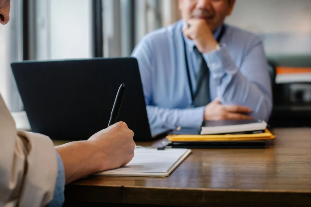 Job candidate filling out an application form during an interview with a recruitment consultant